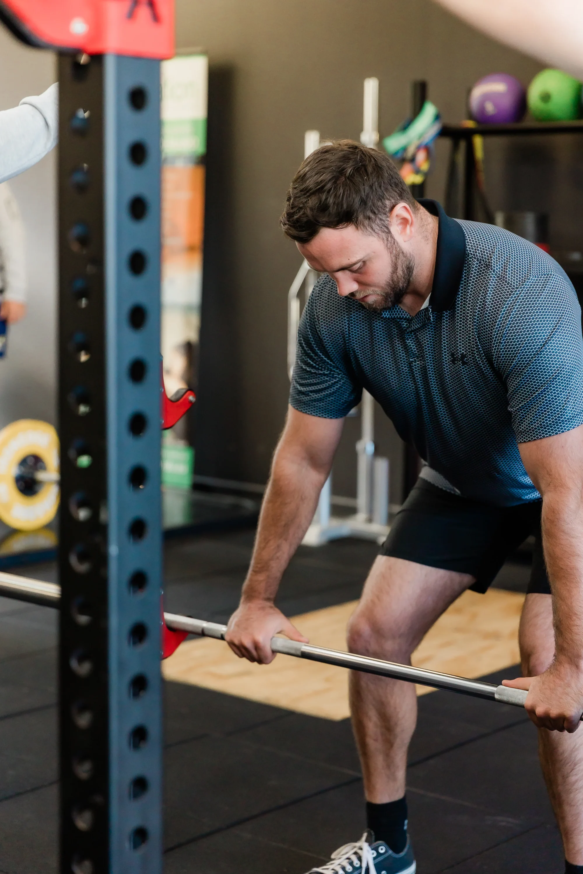 Male in gym performing a lower body barbell exercise