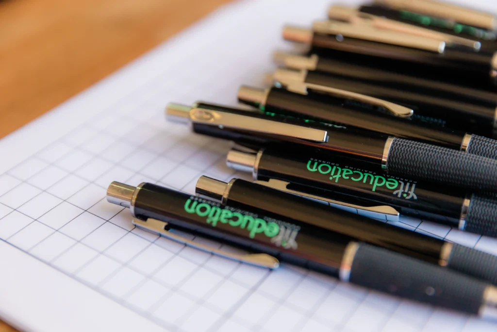 Close up shot of FitEducation branded pens