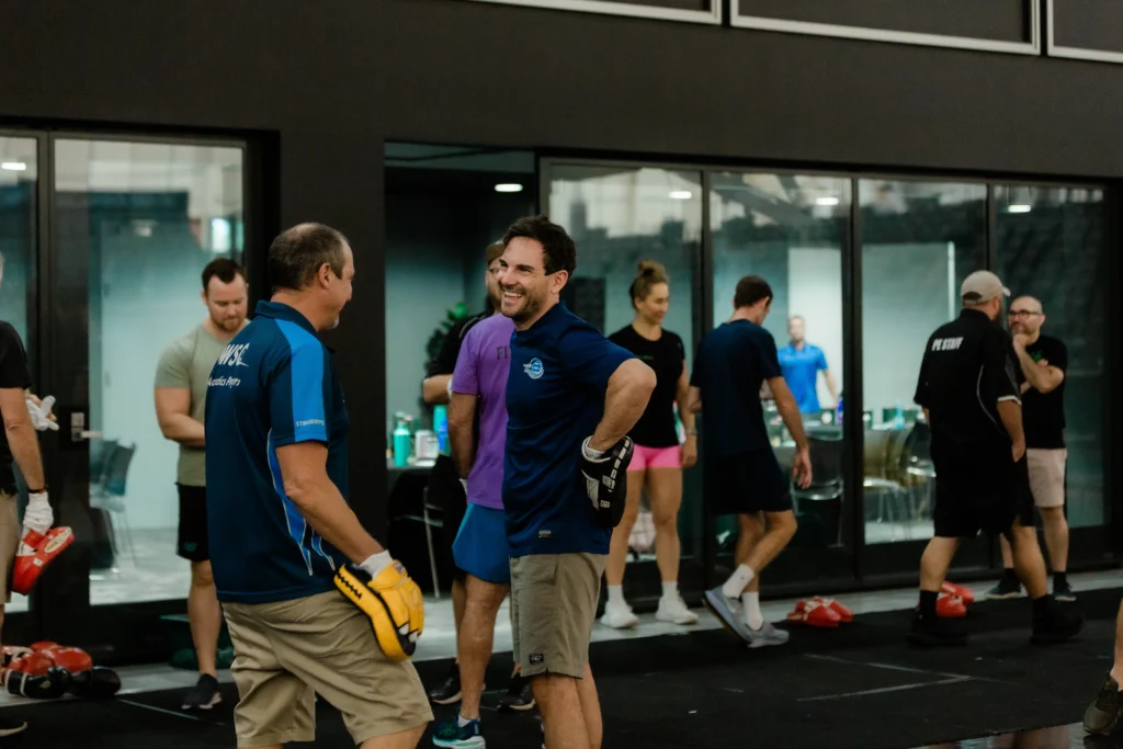 Group of fitness enthusiasts smiling in boxing class