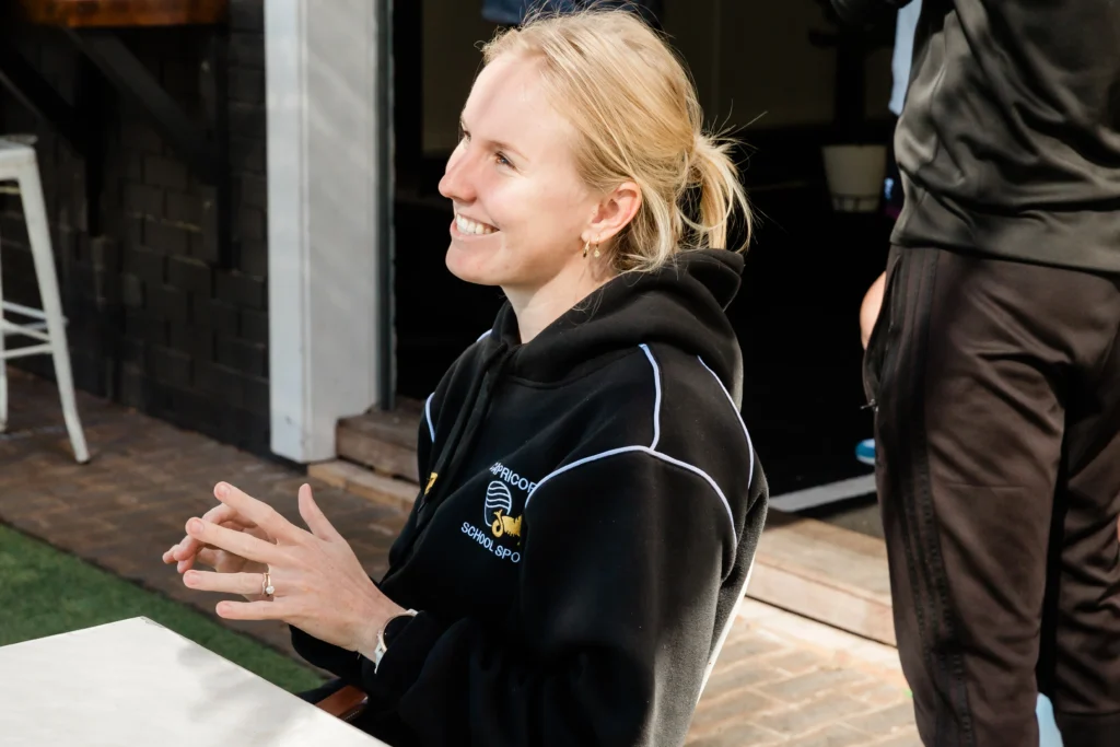 Female coach sitting outdoors and smiling