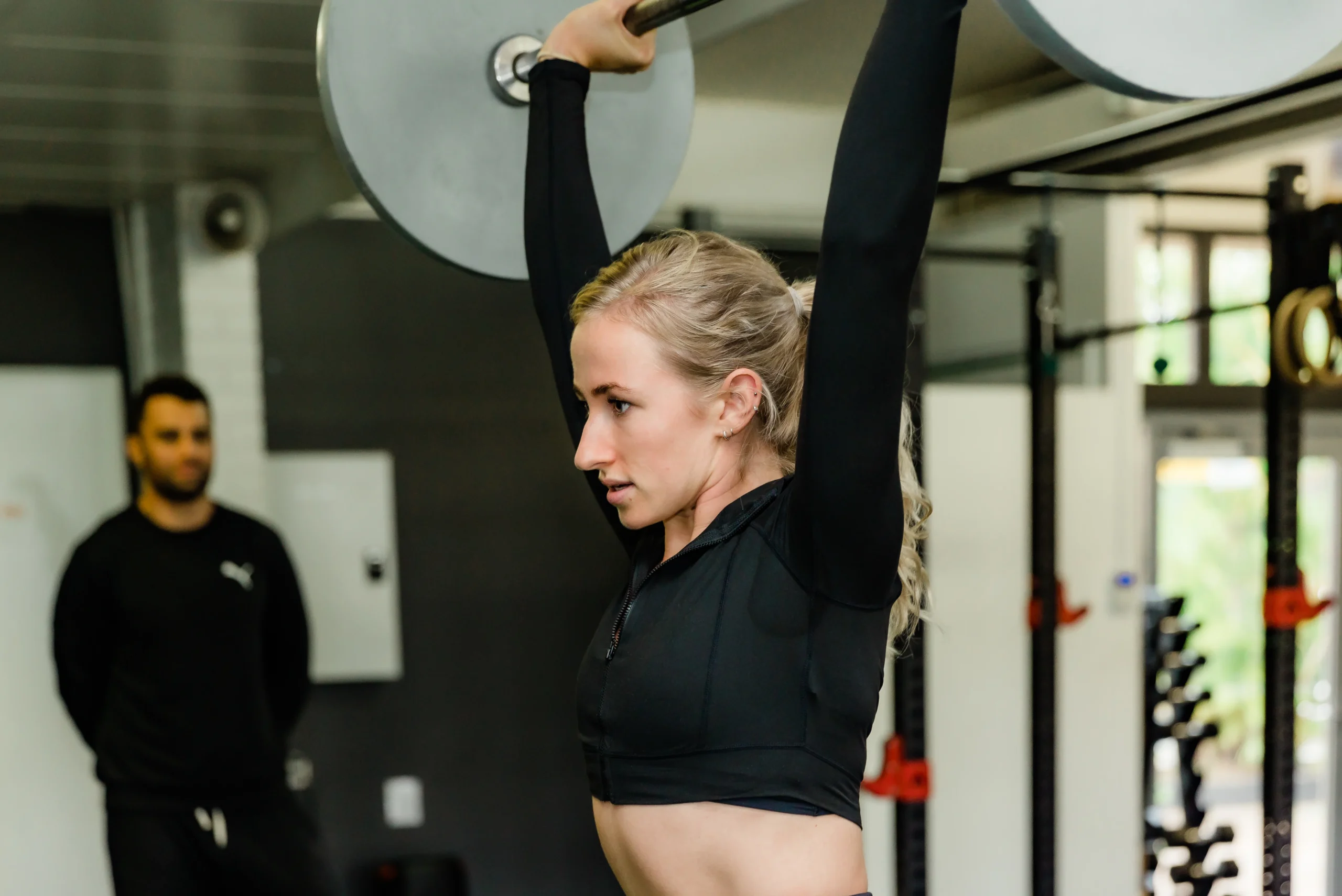 Aspiring female coach performing overhead press