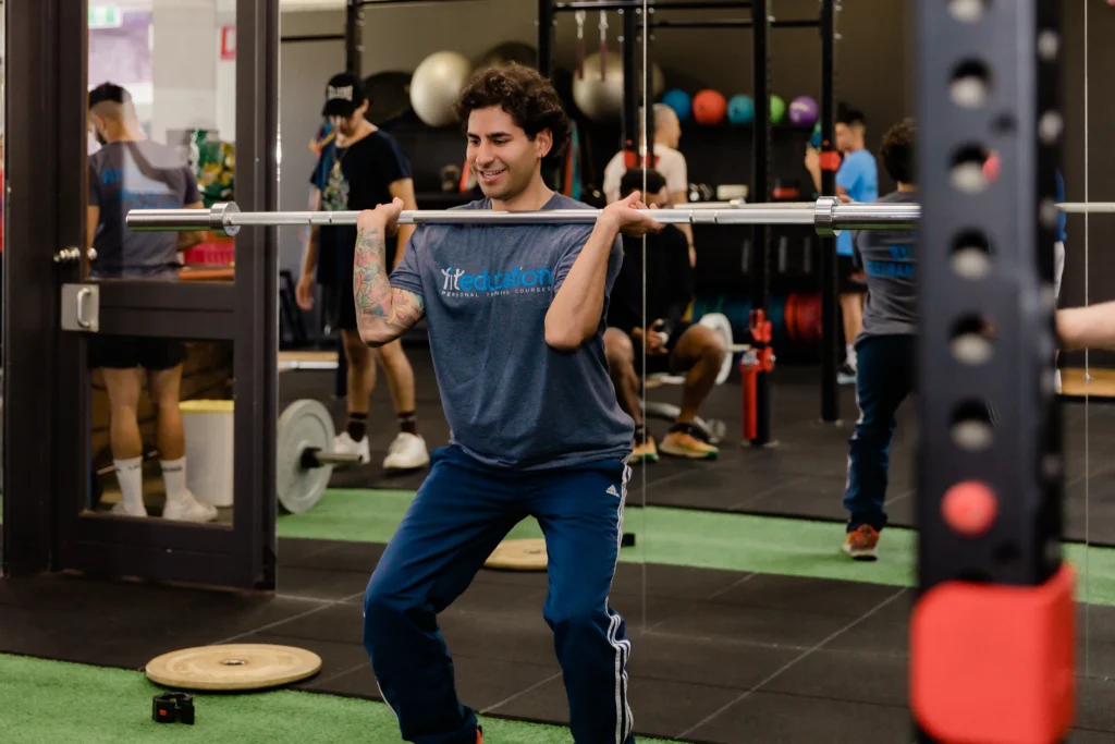 Personal training client performing an overhead press in gym